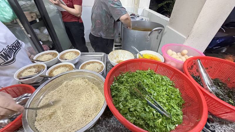 Quầy chuẩn bị của Quán Hương với những bát cháo ấu tẩu, rổ rau thơm và trứng